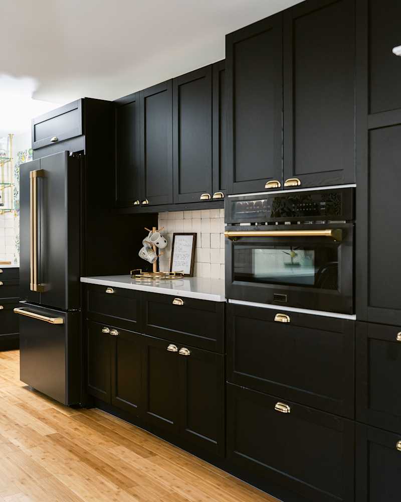 New stove in kitchen with black cabinets.