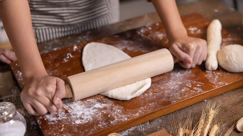 Hands rolling out dough