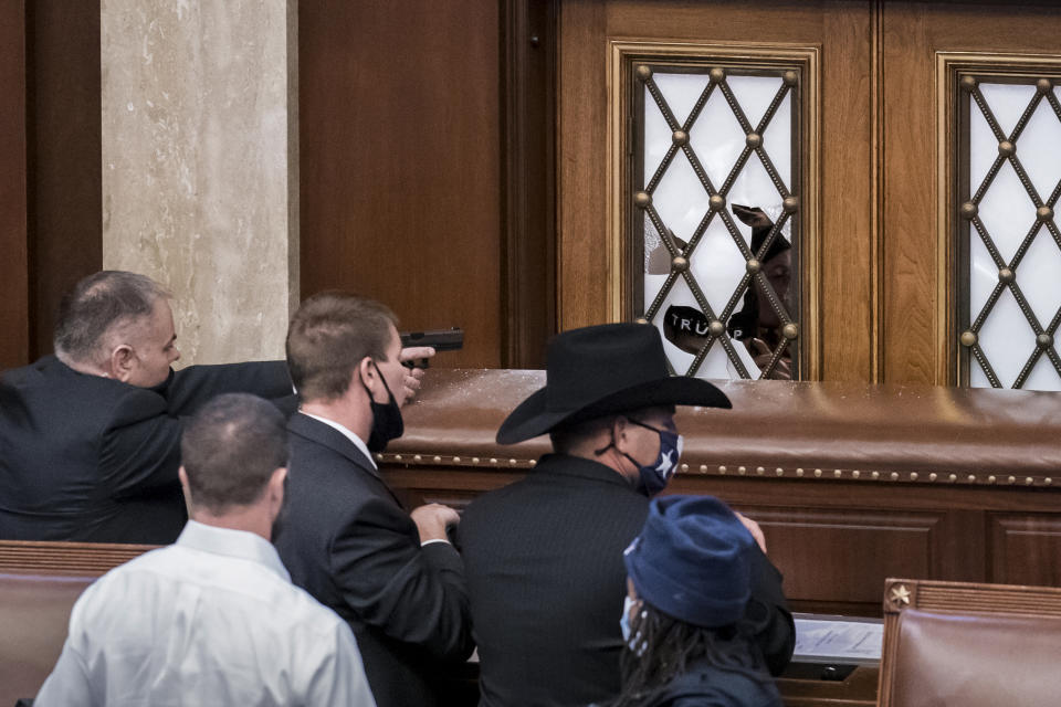 FILE - In this Jan. 6, 2021 file photo, security agents and lawmakers barricade the door to the House chamber as violent mob loyal to then-President Donald Trump, breached the Capitol in Washington and disrupted the Electoral College process. Key figures in the Jan. 6 riot on U.S. Capitol spoke about their desire to overthrow the government, but to date, U.S prosecutors have charged no one with sedition. They could still add them. But prosecutors may be reluctant to bring them because of their legal complexity and the difficulty in securing convictions. (AP Photo/J. Scott Applewhite)