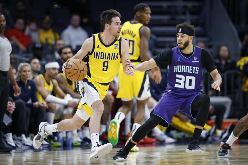 Indiana Pacers guard T.J. McConnell (9) moves the ball against Charlotte Hornets guard Seth Curry (30) during the first half of an NBA basketball game in Charlotte, N.C., Monday, Feb. 12, 2024. (AP Photo/Nell Redmond)