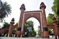 A motorcyclist enters the gate of Aligarh Muslim University in Aligarh, India, Saturday, June 12, 2021. Within just one month, the official Facebook page of Aligarh Muslim University, one of the topmost in India, published about two dozen obituaries of its teachers, all lost to the pandemic. Across the country, the deaths of educators during the devastating surge in April and May have left students and staff members grief-stricken and close-knit university communities shaken. (AP Photo/Manoj Aligadi)