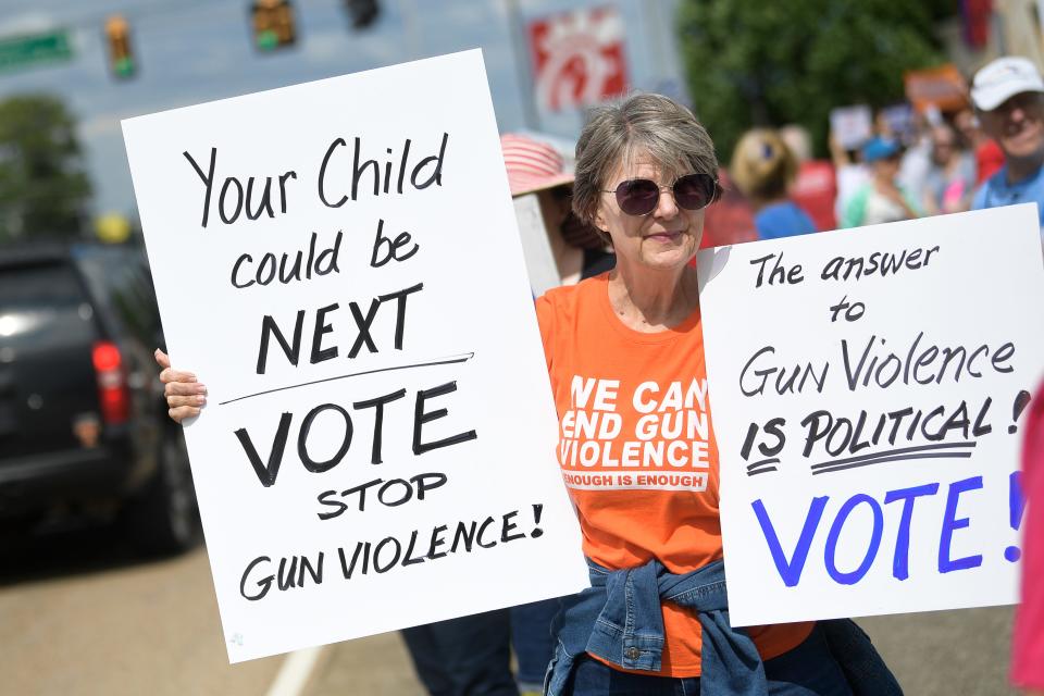 A demonstrator holds signs against gun violence at a demonstration in Knoxville, Tenn. on May 27.