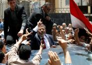 FILE PHOTO - Presidential candidate Mohamed Morsy of the Muslim Brotherhood waves to his supporters after casting his vote at a polling station in a school in Al-Sharqya