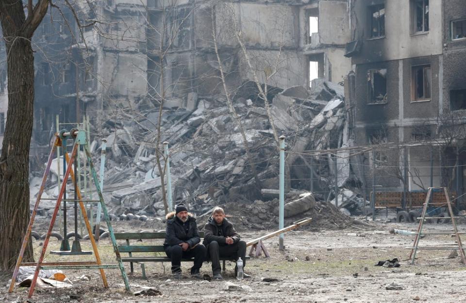 Local residents sit on a bench in the besieged city of Mariupol (REUTERS)