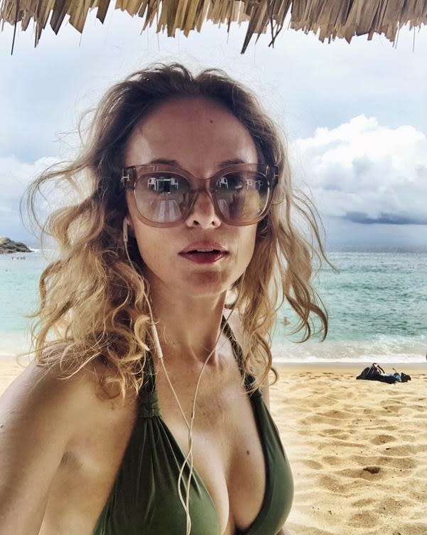 Heather Graham in a green bikini on a beach