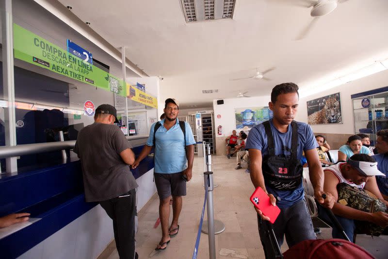 FILE PHOTO: Migrants who left a caravan, after receiving documents to cross the country, wait to board a bus, in Huixtla