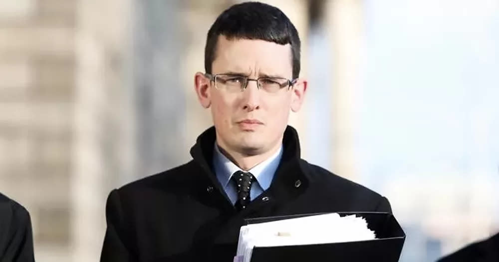 Enoch Burke, who risks prison again, holding a folder with documents on his court case.