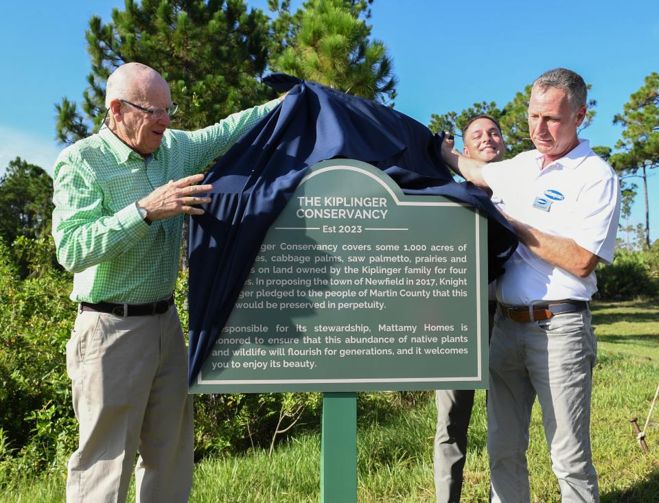 Former economic journalist Knight Kiplinger (left) and Dan Grosswald, of Mattamy Homes, unveil the plaque commemorating the initial trailhead at the Trails at Kiplinger Conservancy (KC Trails) located along S.W Citrus Blvd. on Wednesday, July 19, 2023, in northern Martin County. KC Trails will provide a network of trails for hiking, mountain biking, and horseback riding set to open this fall in Mattamy Homes' Newfield development.