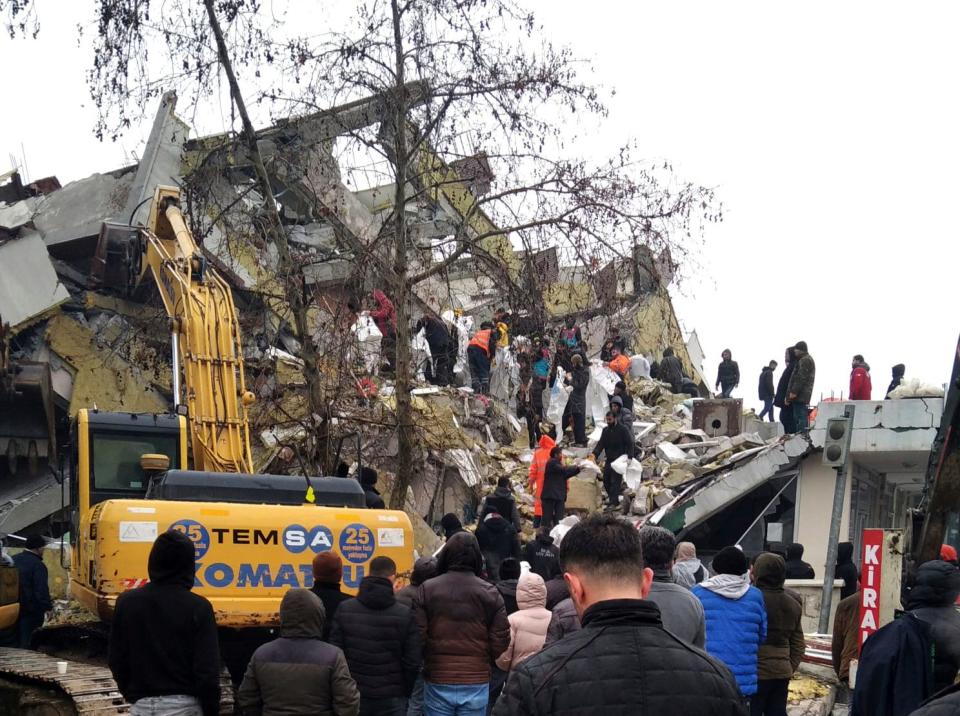 Rescue workers try to reach trapped residents in a collapsed building in Kahta, in Adiyaman province, southeastern Turkey, Monday, Feb. 6, 2023.