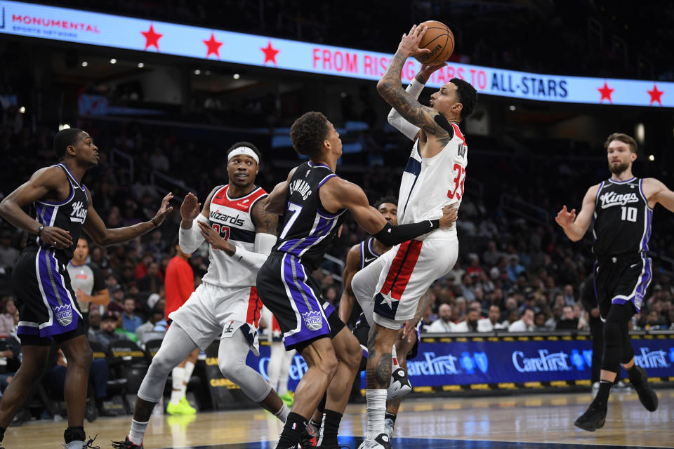 Washington Wizards forward Kyle Kuzma, center right, scores over Sacramento Kings forward Kessler Edwards during the first half of an NBA basketball game Thursday, March 21, 2024, in Washington. (AP Photo/John McDonnell)