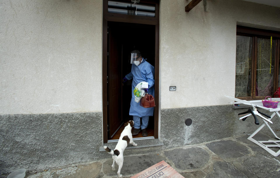 Doctor Mauro Morganti wears protective gear as he leaves after doing a house call on a COVID-19 patient, in Campo Tartano, near Sondrio, Italy, Tuesday, Dec. 1, 2020. (AP Photo/Antonio Calanni)