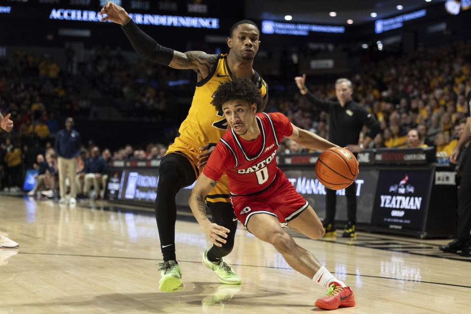 Dayton's Javon Bennett (0) drives past Virginia Commonwealth's Zeb Jackson (2) during the first half of an NCAA college basketball game Friday, Feb. 9, 2024, in Richmond, Va. (AP Photo/Mike Kropf)