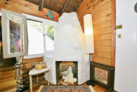 <p>The home features wood beams, bespoke windows and hand-cut stable doors, as well as this fireplace. (Airbnb) </p>