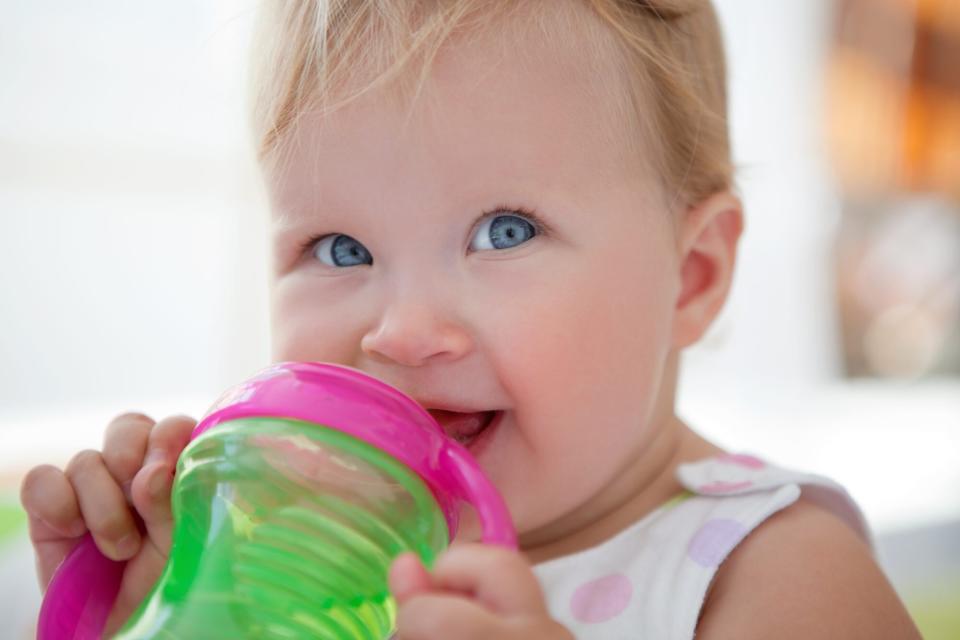 An image of a toddler drinking from a sippy cup.
