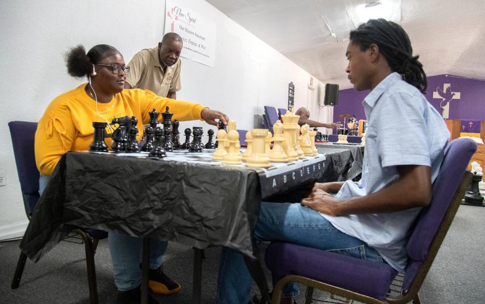 Lenard Seawood, standing, watches as Dayjah Jakes, 18, left, and Ray Irvin, 17, play chess during a free chess day put on by the nonprofit chess mentorship program Every Move Counts at the New Spirit Missionary Baptist Church in south Stockton on June, 24, 2023.