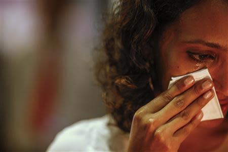 Una mujer llora durante una vigilia por los pasajeros del vuelo MH370 de Malaysia Airlines en Kuala Lumpur, mar 27 2014. REUTERS/Athit Perawongmetha