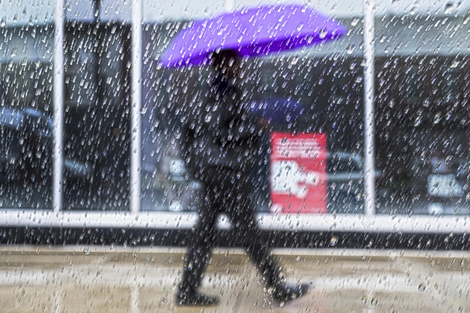 Raindrops fall on a window pane as a pedestrian walks by on Tuesday, Apr 4, 2024, during a heavy rainfall in Philadelphia. (Jose F. Moreno/The Philadelphia Inquirer via AP)