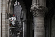 FILE - In this May 15, 2019 file photo, a worker stands on scaffolding during preliminary work inside the Notre Dame de Paris Cathedral, in Paris. The billionaire French donors that publicly promised flashy donations totalling hundreds of millions to restore Notre Dame, have not yet paid a penny toward the restoration of the French national monument, according to church and business officials. Instead, it's mainly American citizens that have footed the bills and paid salaries for the up to 150 workers employed by the cathedral since the April 15 fire. (Philippe Lopez/Pool via AP, File)