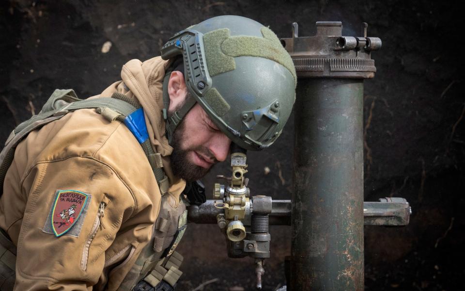 Ukrainian serviceman of the 28th Separate Mechanised Brigade aims a 122mm mortar before firing towards Russian positions