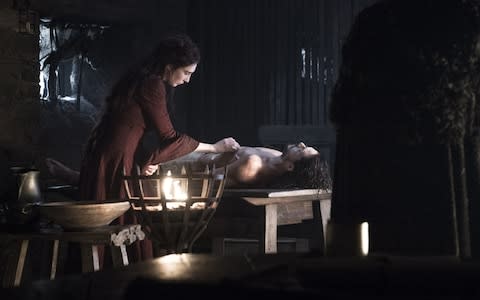 Melisandre (Carice van Houten) tending to the corpse of Jon Snow (Kit Harington) - Credit: HBO