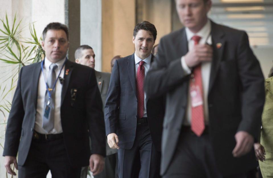 Security walk through the halls of the UN with Prime Minister Justin Trudeau as he arrives at the United Nations headquarters in New York, Wednesday, March 16, 2016. THE CANADIAN PRESS/Adrian Wyld