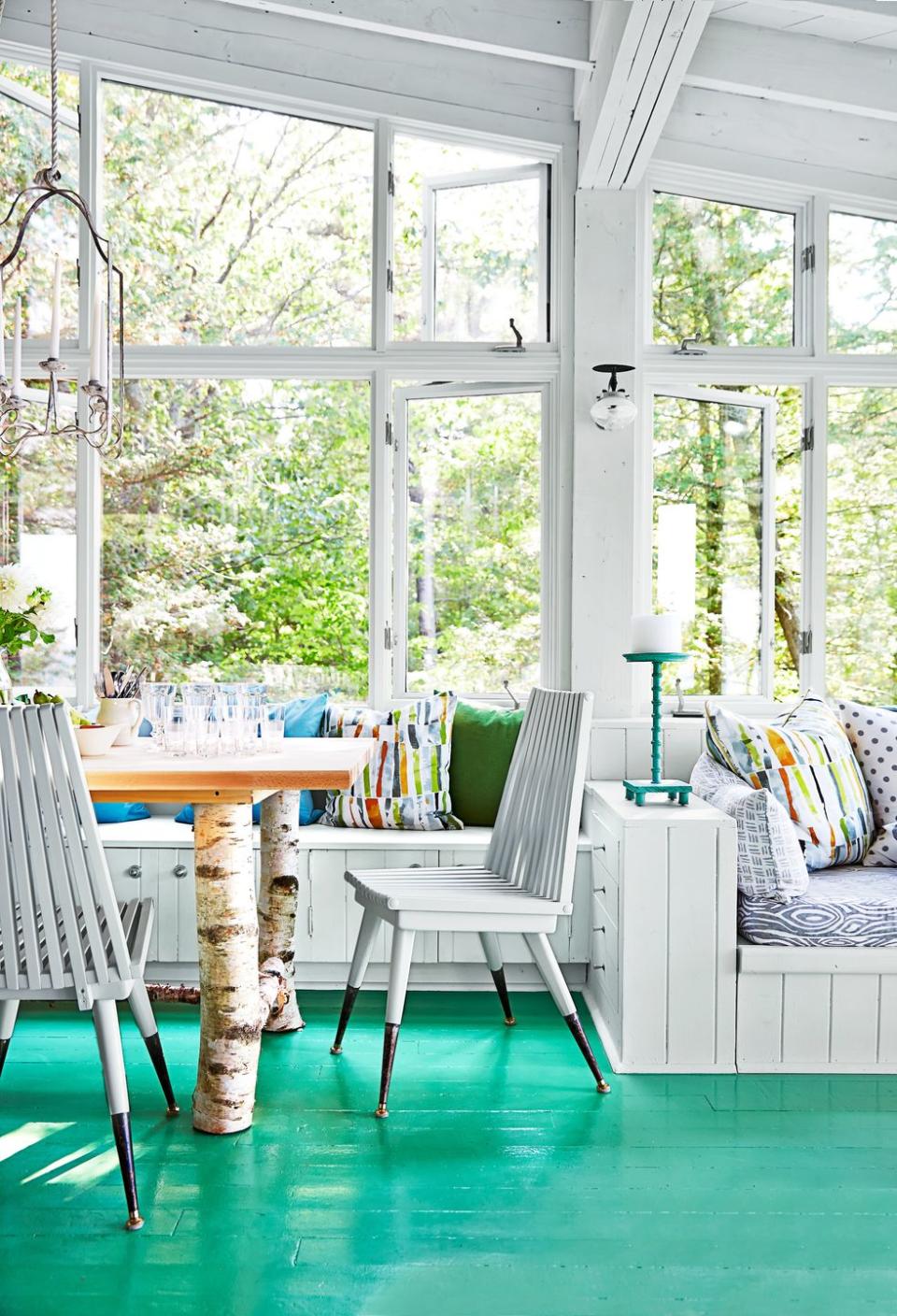 a sunroom with a table and chairs