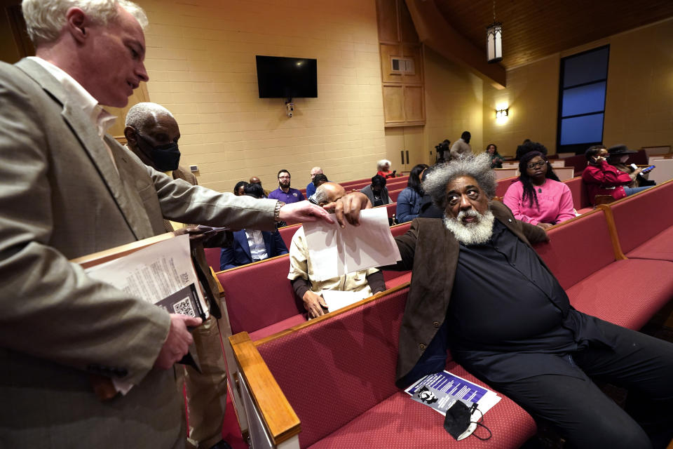 Mississippi state Sen. David Blount, D-Jackson, left, hands out information about a Capital Complex Improvement District expansion bill during a Feb. 14, 2023, meeting at a church in Jackson, Miss. Blount and other Jackson and Hinds County officials oppose the bill that could create a court system with appointed rather than elected judges in Mississippi's capital city. (AP Photo/Rogelio V. Solis)