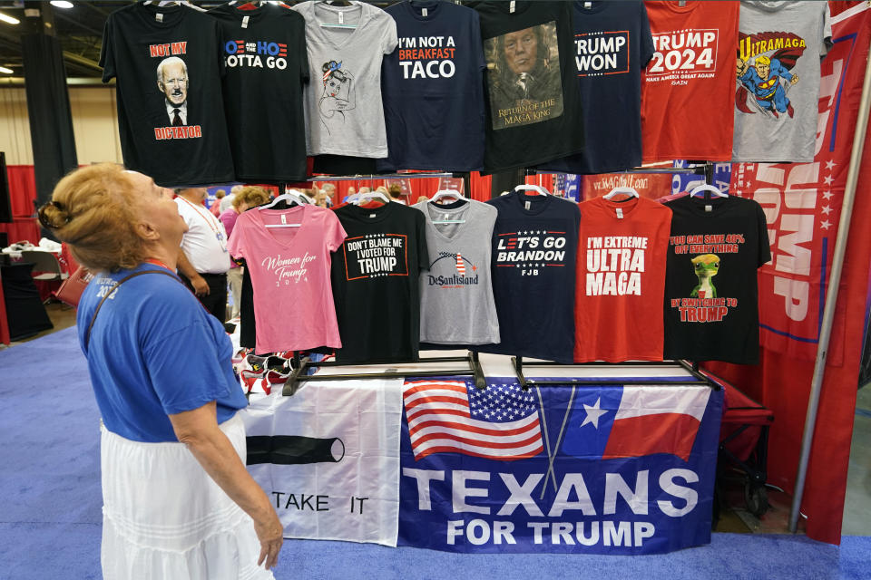 FILE - Maura C Jans of Rio Rancho, N.M., laughs as she looks at T-shirts for sale at the Conservative Political Action Conference (CPAC) in Dallas, Aug. 4, 2022. (AP Photo/LM Otero, File)
