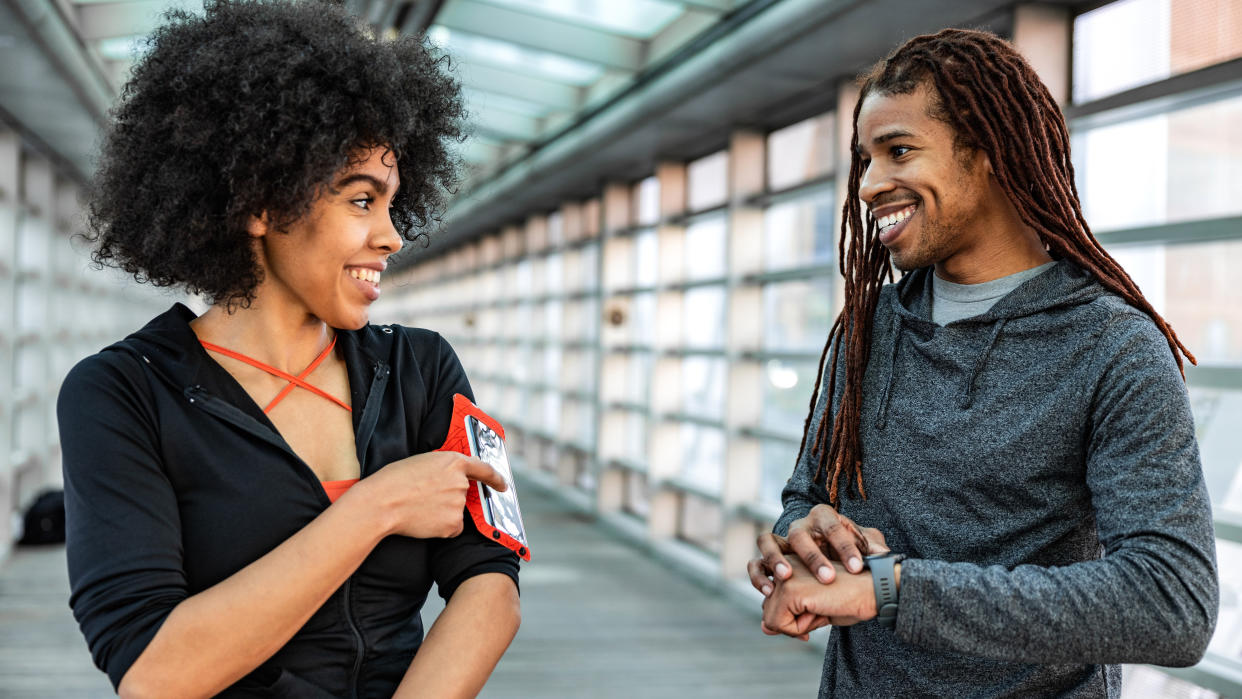  Couple preparing to record workout with GPS watch and phone 