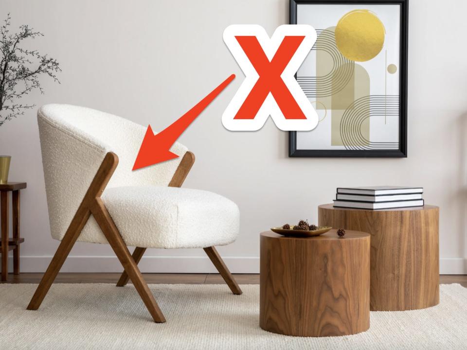 red x and arrow pointing at a boucle chair in a modern living room