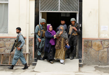 Women react as they walk past Afghan soldiers outside a hospital after multiple explosions in Kabul, Afghanistan, March 21, 2019. REUTERS/Parwiz