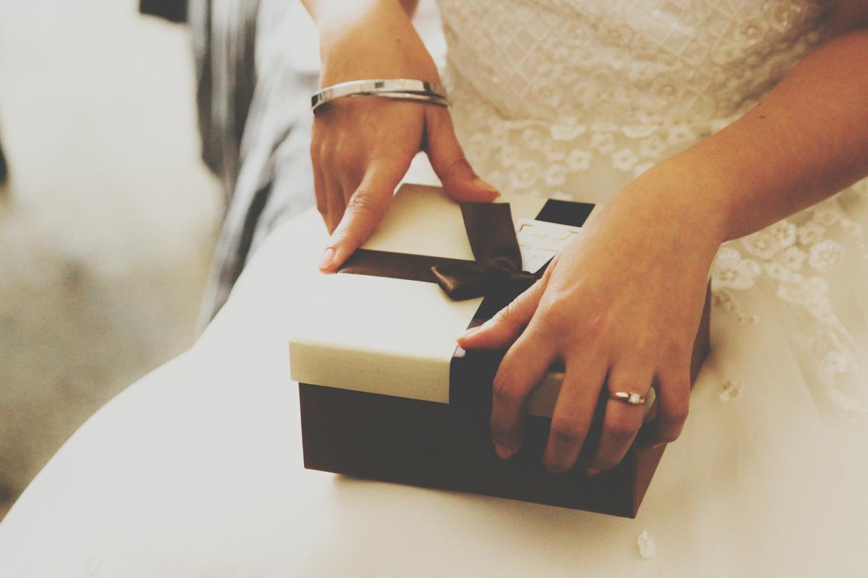 Midsection Of Bride Sitting With Gift