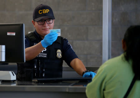 A U.S. Customs and Border Patrol officer interviews people entering the United States from Mexico at the border crossing in San Ysidro, California, U.S. on October 14, 2016. Picture taken on October 14, 2016. REUTERS/Mike Blake