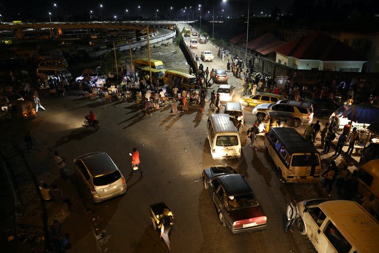 A busy nighttime street packed with market stalls.