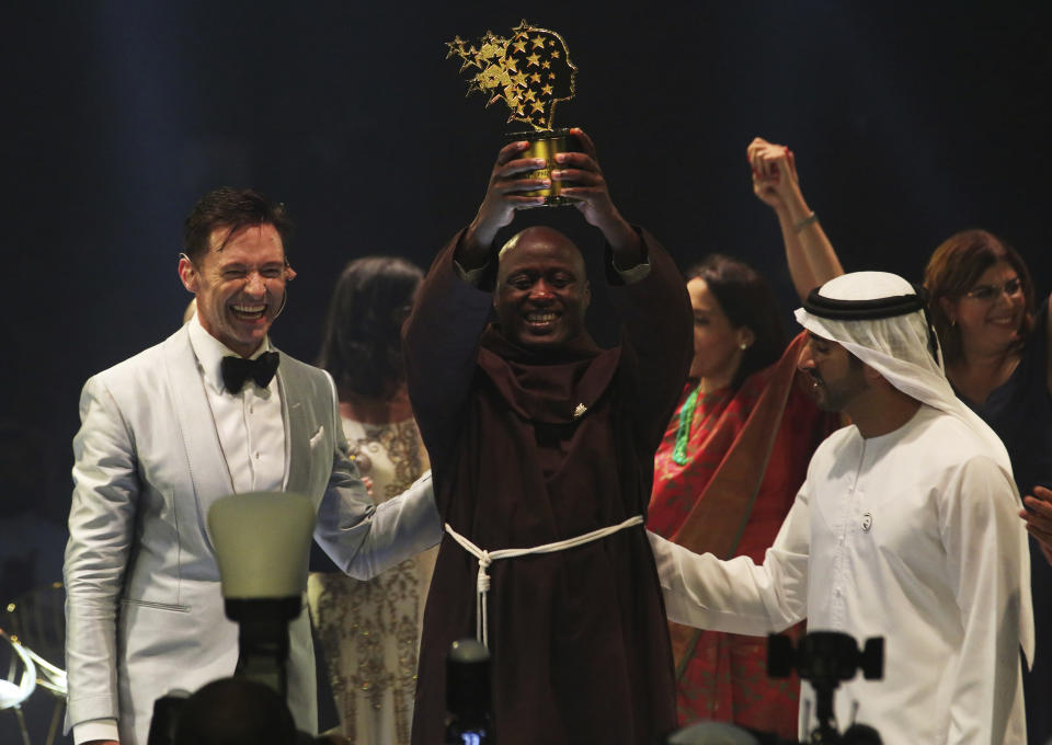 Von links nach rechts: Schauspieler und Laudator Hugh Jackman, Preisträger Peter Tabichi und Kronprinz Sheikh Hamdan bin Mohammed Al Maktoum, der den Preis übergeben hatte. Foto: AP Photo / Jon Gambrell