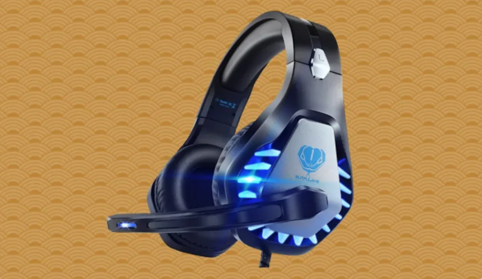 A bulky pair of black gaming headphones with glowing blue ear cups and a microphone