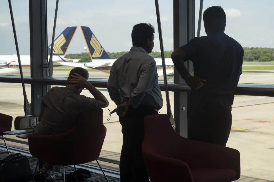 Travelers in a waiting area near Singapore Airlines Ltd. aircraft at Changi Airport in Singapore, on Wednesday, March 30, 2022. Photographer: Ore Huiying/Bloomberg