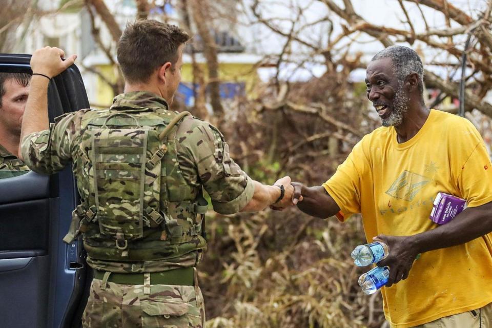 A troop from Alpha Company shaking hands with a local resident in the remote west of Tortola, following Hurricane Maria (PA)