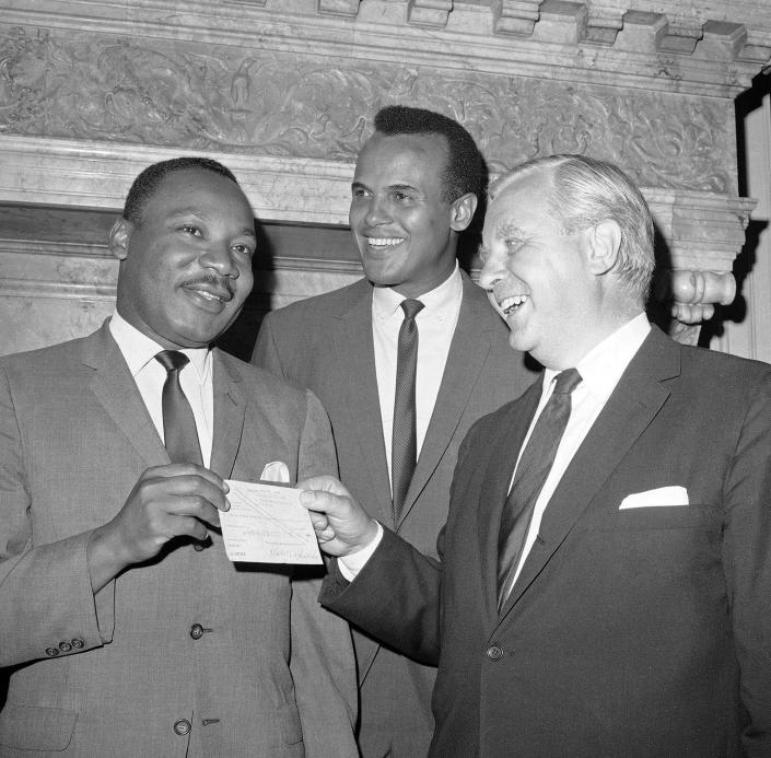 <p>The Consul-General for Sweden in New York City, Tore Tallroth, right, presents a $100,000 check to Dr. Martin Luther King, left, at Sweden House in New York, July 5, 1966. Singer-actor Harry Belafonte stands at center. (AP Photo/Jacob Harris) </p>