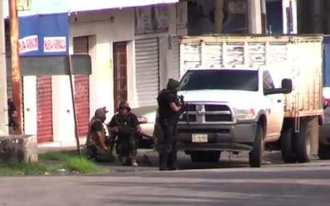 An AFPTV screen grab shows armed gunmen in position during a shootout with authorities in Culiacan, capital of jailed kingpin Joaquin "El Chapo" Guzman's home state of Sinaloa. - Credit: GETTY