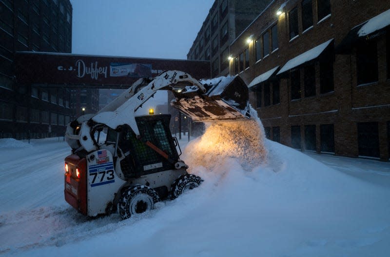 A worker with RJM Construction clears snow from a work site on February 23, 2023 in Minneapolis, Minnesota. 