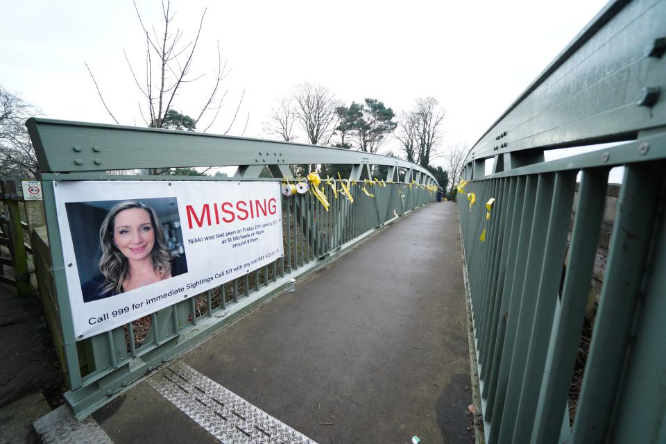 A missing person appeal poster for Nicola Bulley and yellow ribbons with messages of hope written on them tied to a bridge over the River Wyre in St Michael's on Wyre, Lancashire, as police continue their search for Ms Bulley, 45, who vanished on January 27 while walking her springer spaniel Willow shortly after dropping her daughters, aged six and nine, at school. Picture date: Tuesday February 14, 2023.