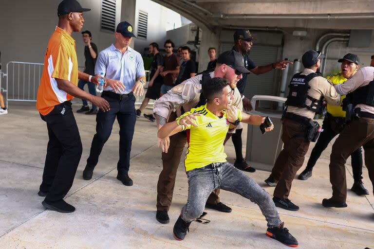 Agentes de policía intentan arrestar a un fanático colombiano afuera del estadio del partido final de la CONMEBOL Copa América 2024 entre Argentina y Colombia