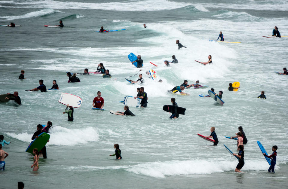 SENNEN COVE, ENGLAND - AUGUST 01: People crowd into the sea to swim, surf and bodyboard at Sennen Cove on August 1, 2021 in Cornwall, England. With international travel restrictions remaining likely for this summer at least, many parts of the UK are set to be very popular with holidaymakers opting to have domestic holiday or a so called staycation within the UK. (Photo by Matt Cardy/Getty Images)