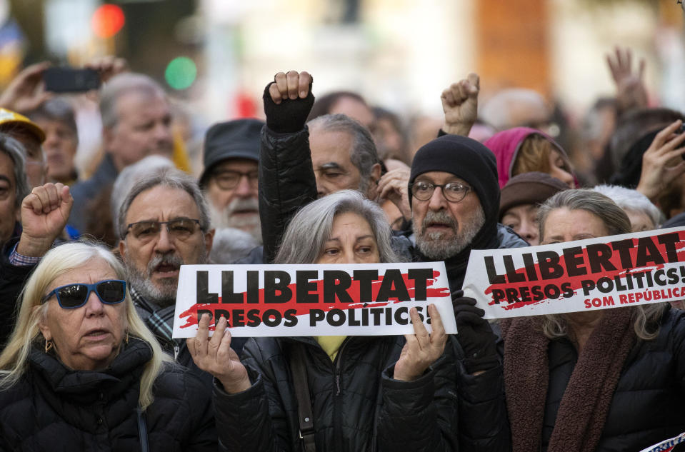 Supporter of Catalan regional president Quim Torra, gather outside Catalonia's high court in Barcelona, Spain, Monday, Nov.18, 2019. The pro-independence regional president of Catalonia is standing trial for allegedly disobeying Spain's electoral board by not removing pro-secession symbols from public buildings during an election campaign. Banner in Catalan reads "Freedom for political prisoners". (AP Photo/Emilio Morenatti)