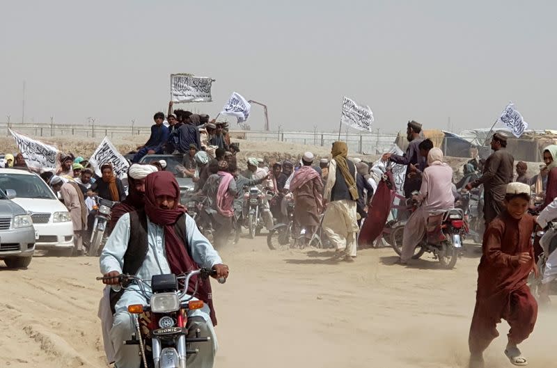 People on vehicles gather near Friendship Gate crossing on Pakistan-Afghanistan border, in Chaman