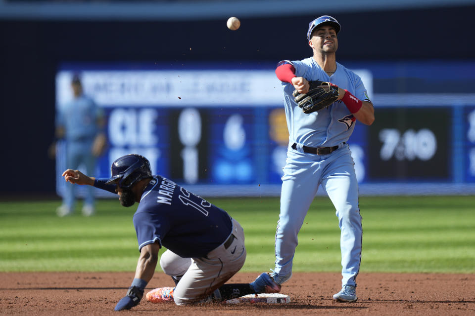 Tampa Bay Rays center fielder Manuel Margot is forced out at second as Toronto Blue Jays second baseman Santiago Espinal makes the play during the second inning of a baseball game in Toronto, Saturday, Sept. 30, 2023. (Frank Gunn/The Canadian Press via AP)
