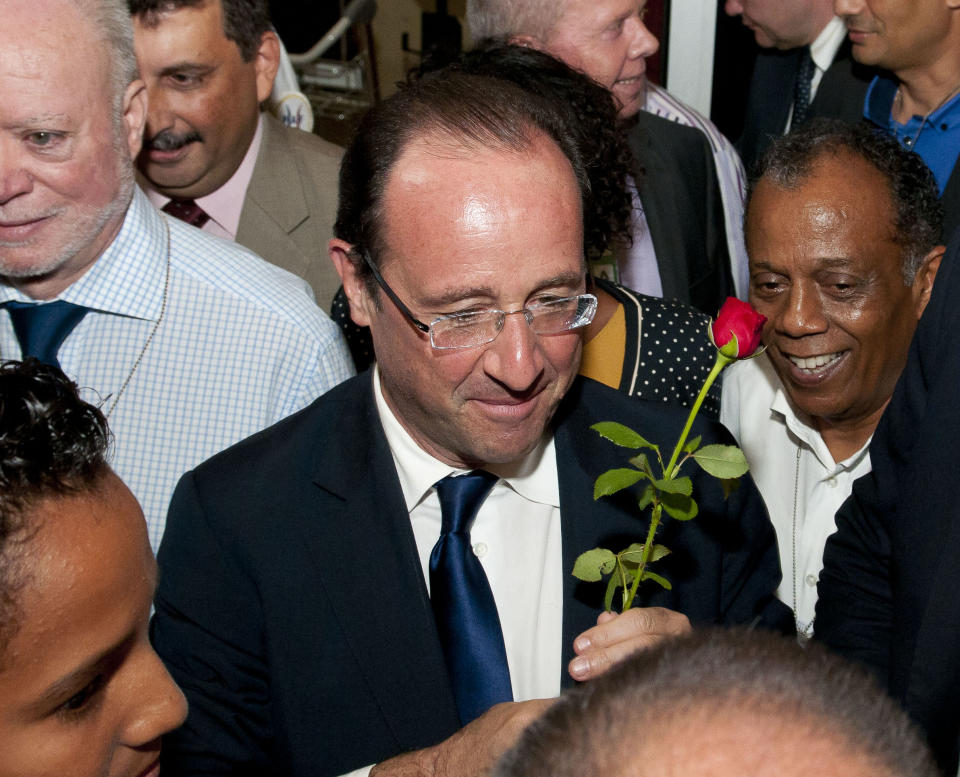 Socialist presidential candidate Francois Hollande holds a rose as he arrives at Saint-Denis de la Reunion airport in La Reunion island, Saturday, March, 31, 2012. Hollande is on a two-day campaign visit to the French island in the Indian Ocean. (AP Photo/Fabrice Wislez)