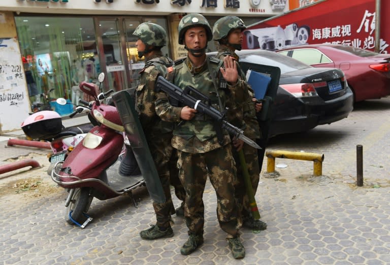 Paramilitary police officers stand guard outside a shopping mall in Hotan, in China's western Xinjiang region on April 16, 2015