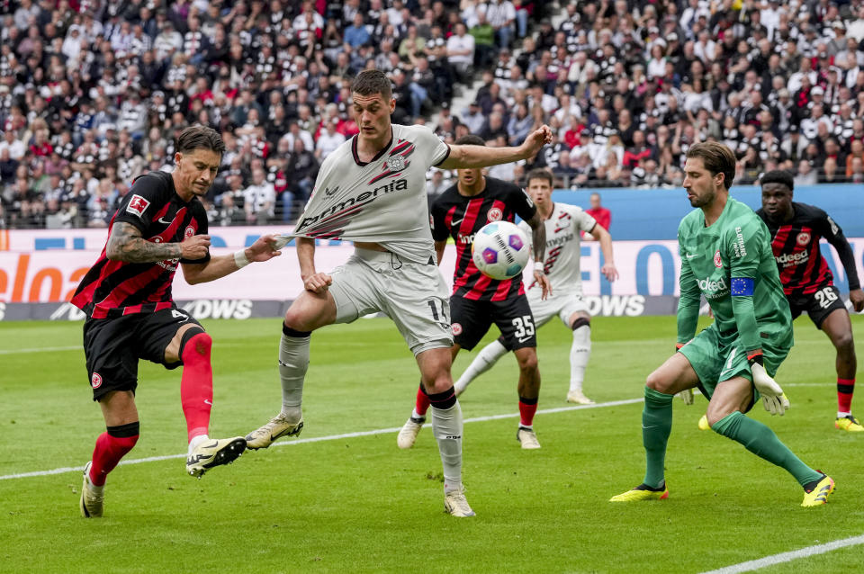 Frankfurt's Robin Koch, Leverkusen's Patrik Schick and Frankfurt's goalkeeper Kevin Trapp, from left, challenge for the ball during the German Bundesliga Soccer match between Eintracht Frankfurt and Bayer Leverkusen in Frankfurt, Germany, Sunday, May 5, 2024. (AP Photo/Michael Probst)